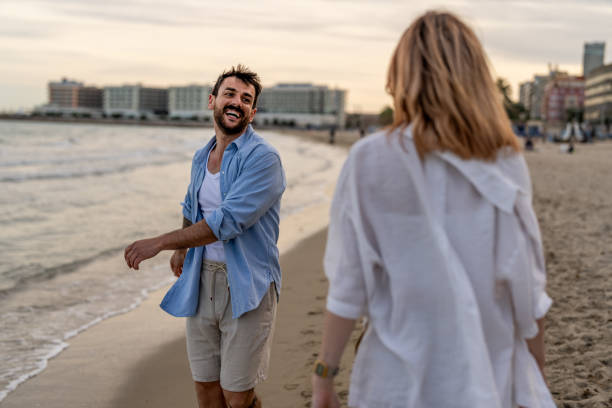 istock Couple walking at beach during sunset 2148134414