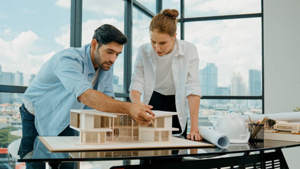 istock Cooperative engineer team working together to measure house model. Tracery 2148134994
