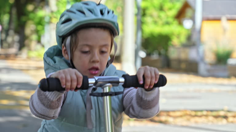 Child Safely Scooting Down The Sidewalk, Wearing Helmet And Warm Clothes
