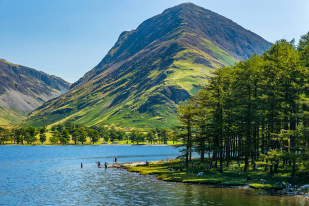 istock Swimmers on a large, calm lake surrounded by mountains on a hot summers day 2148135424
