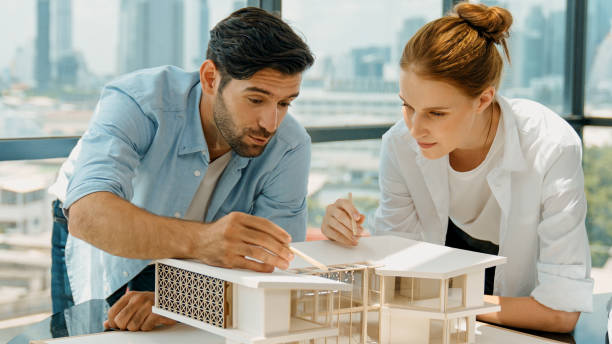 istock Cooperative engineer team working together to measure house model. Tracery 2148135521