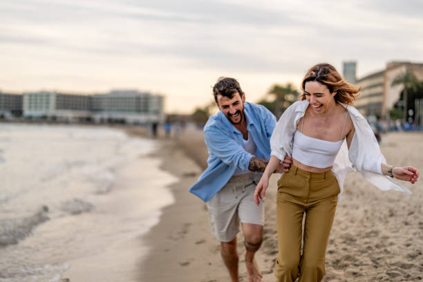 istock Couple Walking Along the Beach 2148135807