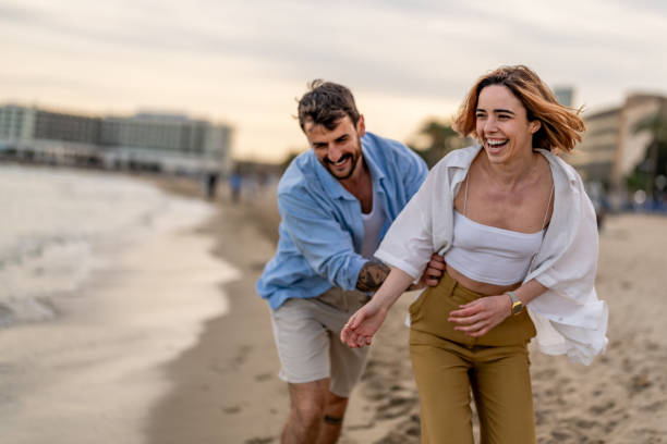 istock Couple Having Fun Running Along Winter Beach Together 2148135808