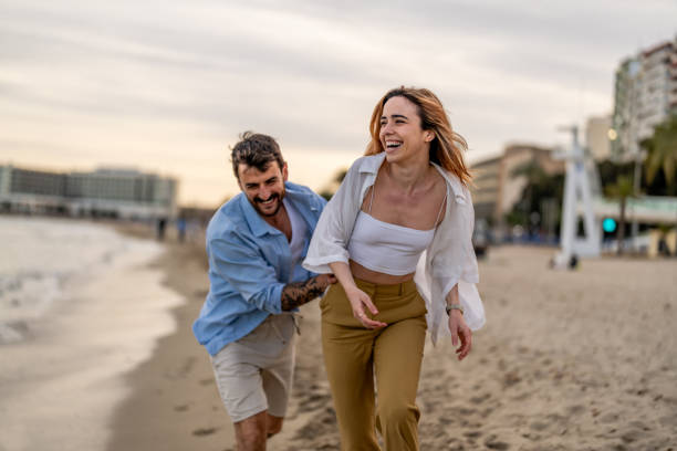 istock Couple Having Fun Running Along Winter Beach Together 2148135818
