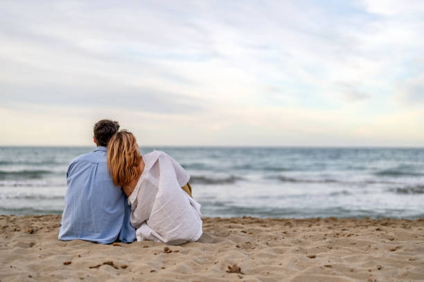 istock Friendship, friends sitting together on the beach 2148135841