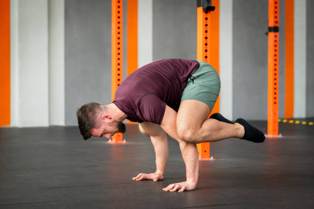 istock Strong man performing calisthenics frog stand exercise in gym 2148136324