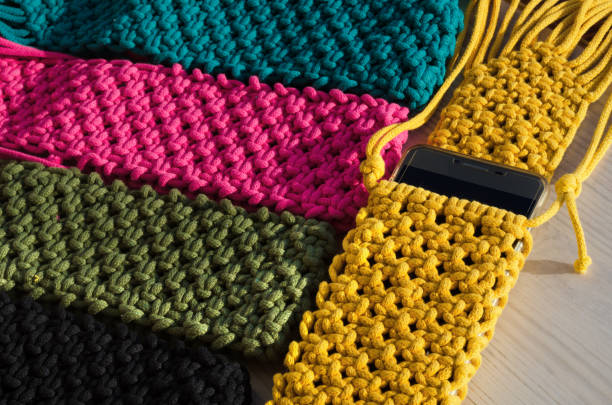 istock Small handbag for a mobile phone. Knitting macrame, pattern of multi-colored cotton cords. Handmade concept, hobby. 2148137368