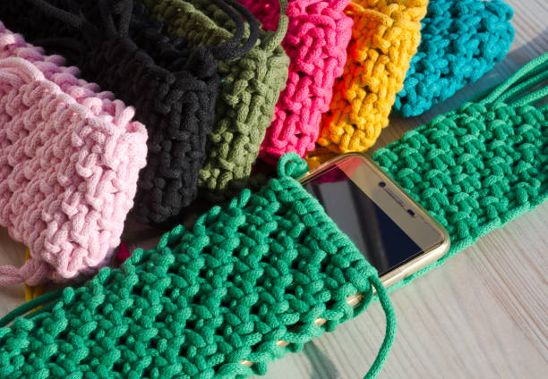 istock Small handbag for a mobile phone. Knitting macrame, pattern of multi-colored cotton cords. Handmade concept, hobby. 2148137396