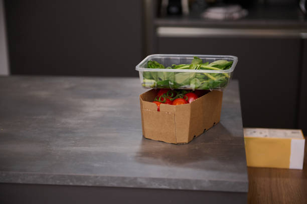istock Fresh organic tomatoes cherry and arugula green leaves in ecologically friendly, recyclable paper box on a gray surface of kitchen table. Ingredients for healthy salad. Food background. Still life. 2148137911