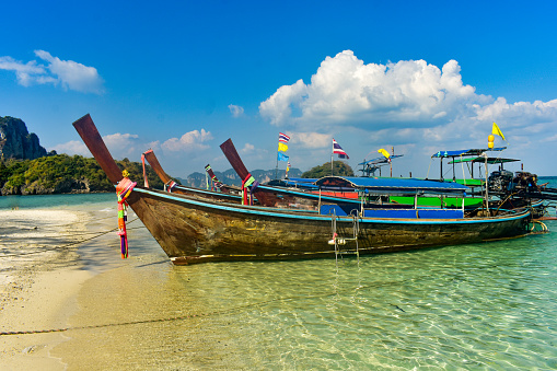 Long tail boats parked on the beach near krabi .