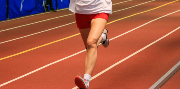 istock Legs of a runner on an indoor track 2148139612