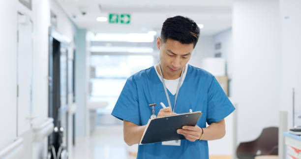 istock Doctor, planning and writing in documents, medical checklist or charts for hospital notes or clinic service. Healthcare worker, asian man or nurse smile for clipboard, paperwork or thinking in clinic 2148139764
