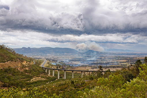 A view over Paarl, Western Cape, South Africa during extreme winds, and fires burning in many places in the valley. The distant mountains are haze because of smoke and dust blowing over the valley.