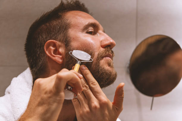 istock Close up shot of a bearded man using a face roller 2148141351