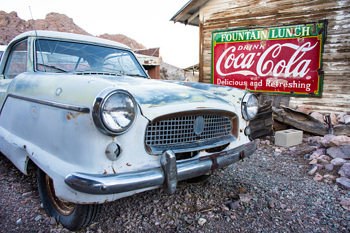 Nelson, Nevada - USA: Antique car under old Coca-Cola sign on deserted barn