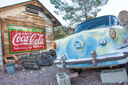 Nelson, Nevada - USA: Antique car under old Coca-Cola sign on deserted barn