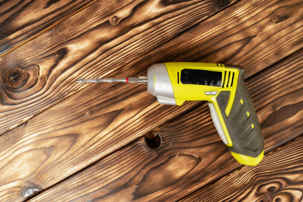 a cordless screwdriver. Cordless drill on a wooden background. DIY concept