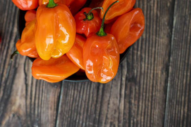 istock Scotch Bonnet hot spicy Peppers on wood Kitchen table 2148145044
