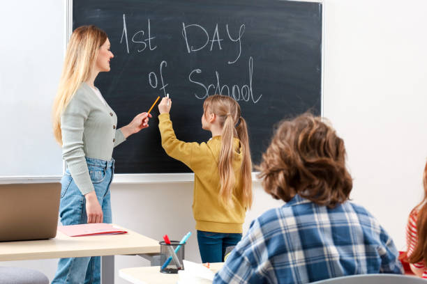 istock Schoolgirl writing something on blackboard in classroom. Education concept. Back to school 2148145314