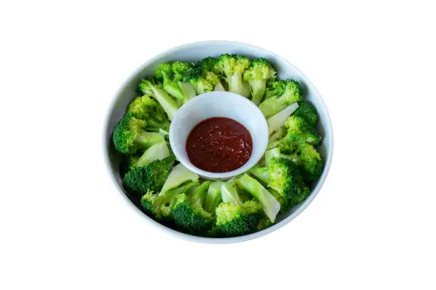 Blanched broccoli and vinegared red chili pepper paste in a salad bowl isolated on white background.
