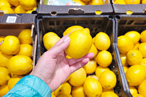 Lemon fruit in buyer hand in store