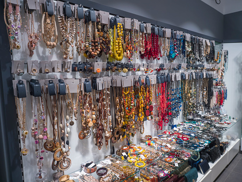 Los Cristianos, Tenerife, Canary Islands, Spain, december 26, 2021: Various colorful bijouterie, imitation jewelry. Handmade necklaces and bracelets at souvenir tourist shop. Selective focus.