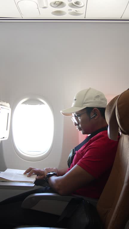 man reading a book on airplane