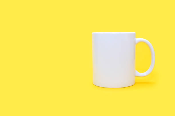 istock White mug on a yellow background with free space for text 2148151098