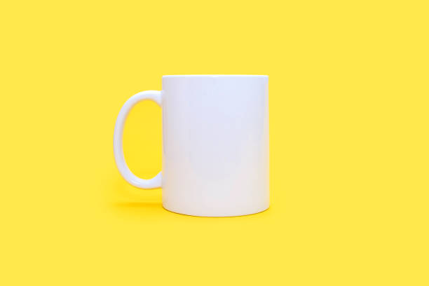 istock White mug on a yellow background in the center 2148151105