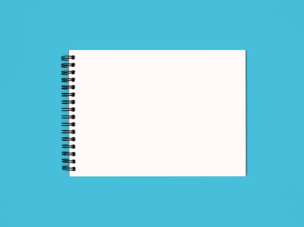 Notebook made of white paper with binding on a blue background. Empty notepad without notes with free space for text. Notebook in a classic binding without marks on a horizontal photo