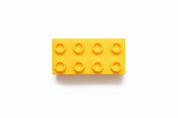 Yellow plastic detail on a white background. One detail of the constructor is isolated on a white background in the center of the frame close-up