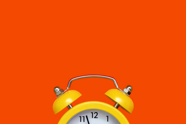 istock Yellow old-fashioned alarm clock with a dial on a orange background with free space for text 2148151256