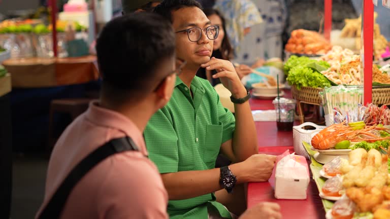 Asian traveler buy Thai style halal barbecue stick food from street vendor