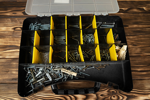 The toolbox is overflowing with a variety of screws and nails, neatly organized and ready for use in household repairs or DIY projects.
