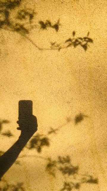 Smartphone Shadow on Yellow Wall