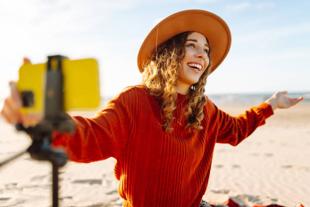 istock Female blogger recording video using smartphone on tripod on the seashore. 2148155392