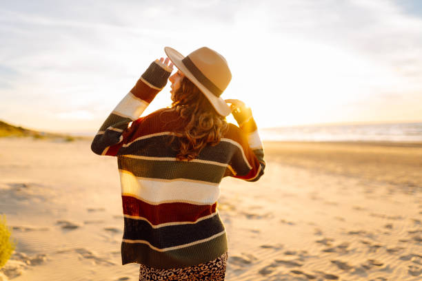 istock Young woman walking along sea at sunset. 2148155605