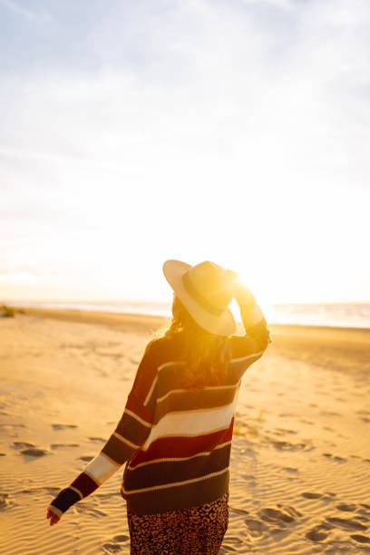 istock Young woman walking along sea at sunset. 2148155644