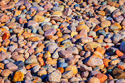 Stones, worn smooth by the endless ocean waves are lit by morning light on a beach in Sandwich, Massachusetts on Cape Cod.