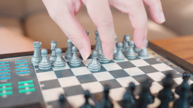 A Man Moving Chess Piece In A Board Game
