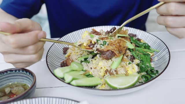 Female scooping Thai fried rice with beef in Thai restaurant