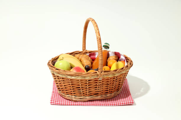 Romantic picnic setting on a haystack with juice, breadsticks, peaches and a straw hat