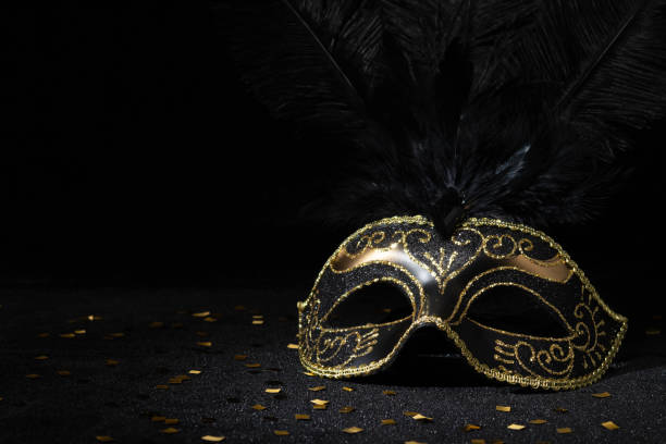 istock Carnival gold mask with feathers and confetties on black background. 2148166872