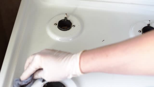 Cleaning gas stove with a rag