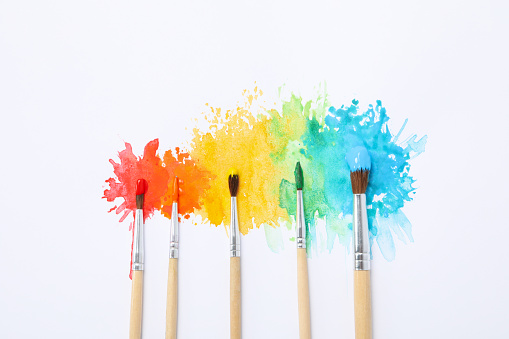 Paint brushes with paints on white background
