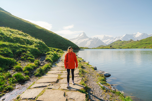 Woman hiking near Bachalpsee lake in Swiss Alps in summer