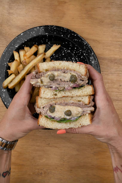 istock A woman holding a vitel tone meat sandwich 2148170710