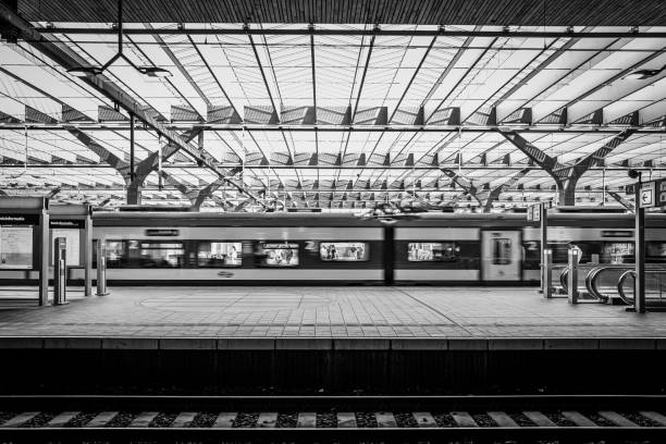 Germany, Berlin, railroad station Spandau, September 28, 2025 - Side view of a woman on an empty platform next to a passenger train