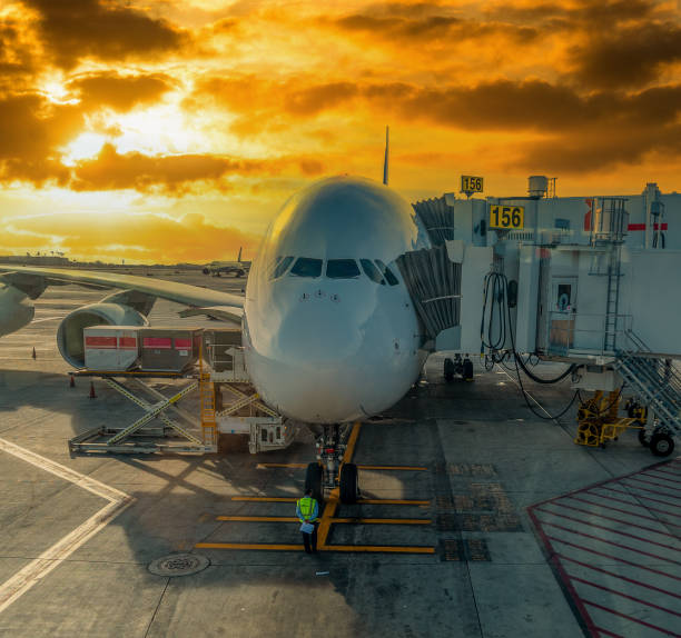 istock Aircraft linked to an aerobridge under an orange sky 2148171124
