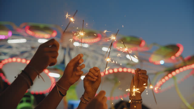 Sparkler Celebration at Nighttime Amusement Park